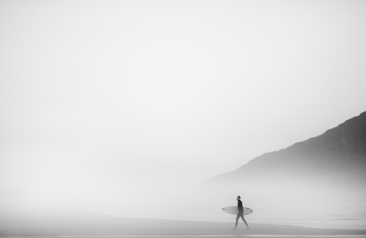 Surfer walking through thick fog